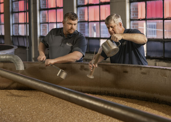 Two distillers check the product at Ross & Squibb Distillery